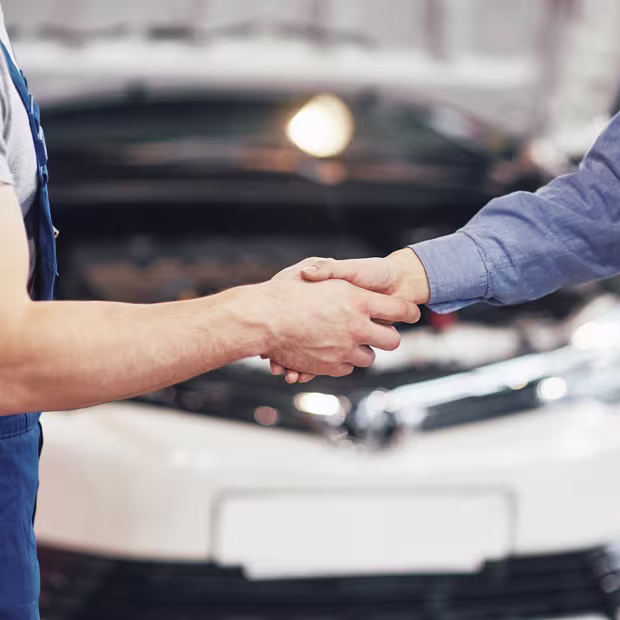 Customer collecting their repaired car and shaking hands with the mechanic
