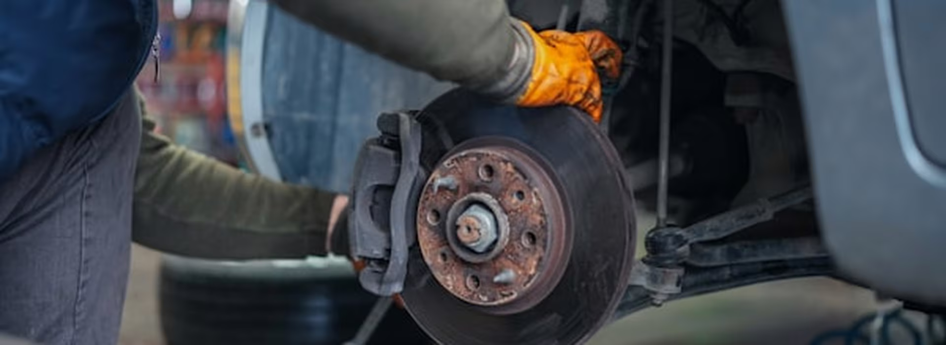 Mechanic replacing a brake disc and pads on a vehicle at Central East Mechanical in Dapto