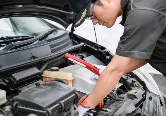 Auto electrician testing a vehicle wiring loom with a multimeter at the Dapto workshop