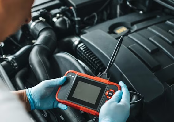 Diagnostic scan tool plugged into a vehicle OBD port reading engine fault codes