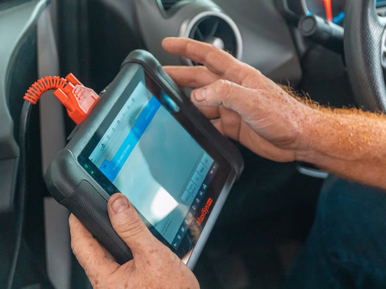 Mechanic reading live fault code data on a diagnostic scan tool plugged into a vehicle at Central East Mechanical in Dapto