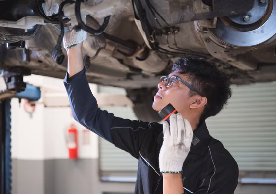 Central East Mechanical technician carrying out a logbook service on a hoisted vehicle in the Dapto workshop